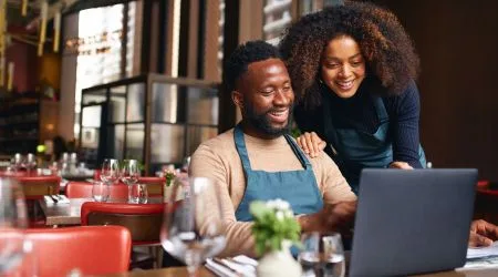 Business owners at restaurant in front of computer