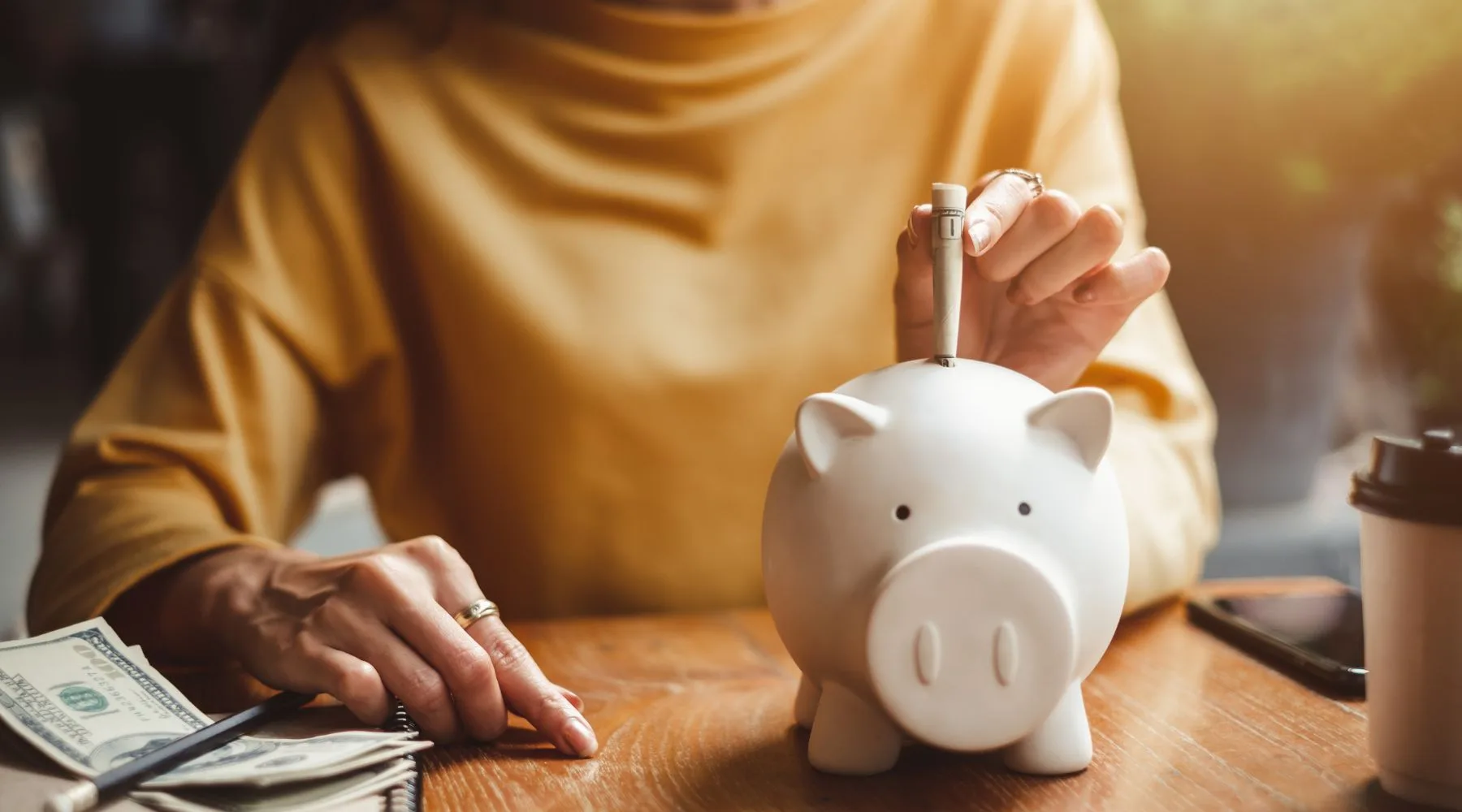 Pink piggy bank next to a savings account book