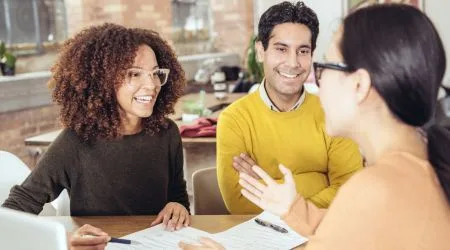 Woman explaining document to couple